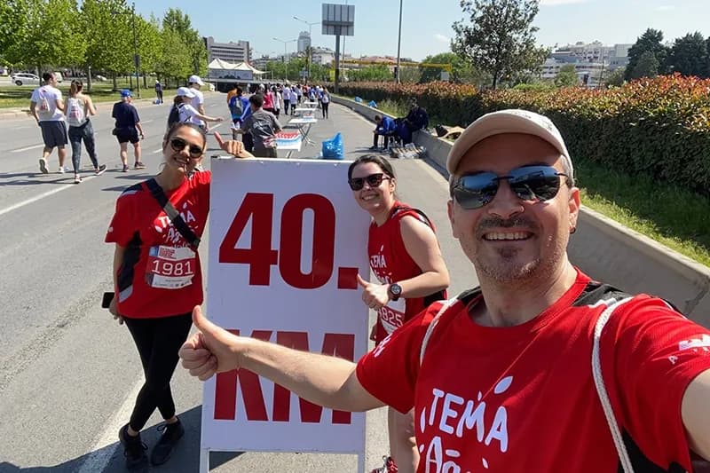 Parkurda kilometre tabelasını tutan katılımcılar