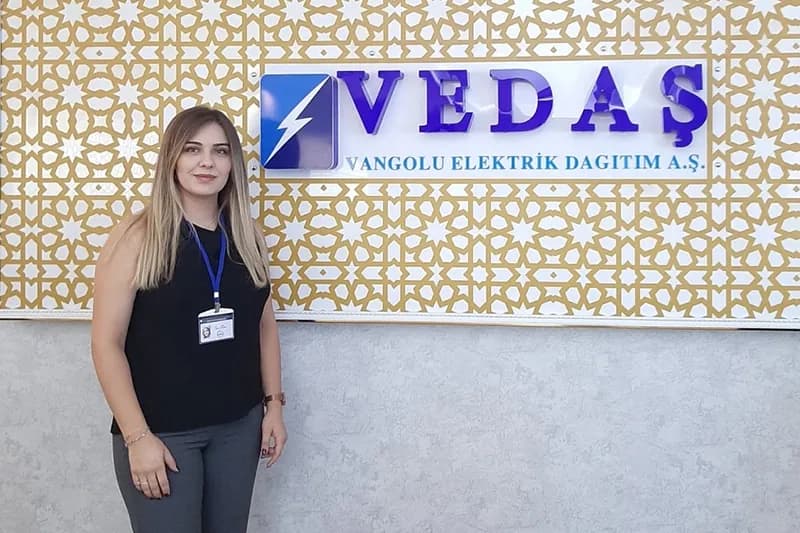 VEDAŞ tabelasının önünde duran katılımcı